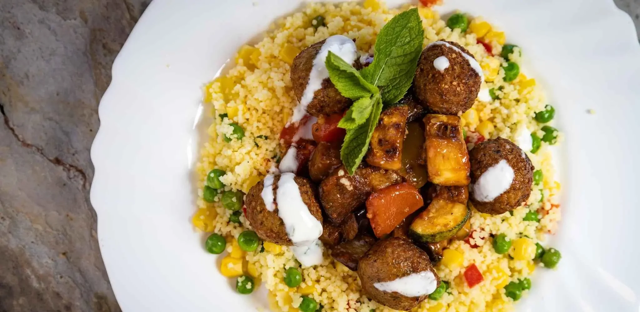 Vegetarisch und frisch: Unsere Falafelbällchen mit Minzsauce und buntem Couscous bringen mediterranen Geschmack in den Kita-Alltag.